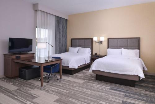 梅森俄亥俄州辛辛那提-梅森汉普顿酒店的酒店客房设有两张床、一张桌子和一台电视。