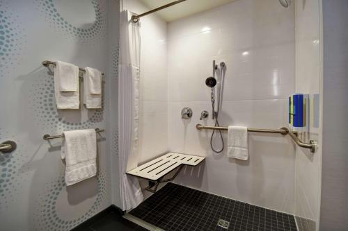 弗洛伦斯Tru By Hilton Cincinnati Airport South Florence的带淋浴和白色毛巾的浴室