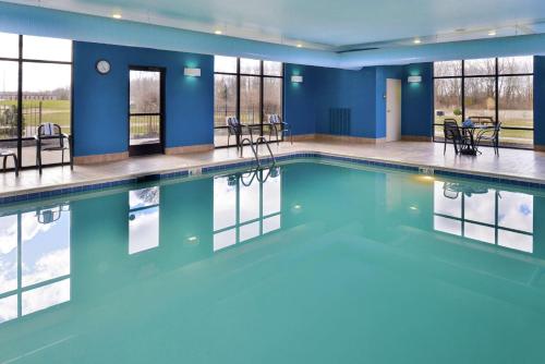 威尔明顿维尔明顿汉普顿套房酒店的一个带蓝色墙壁和窗户的游泳池