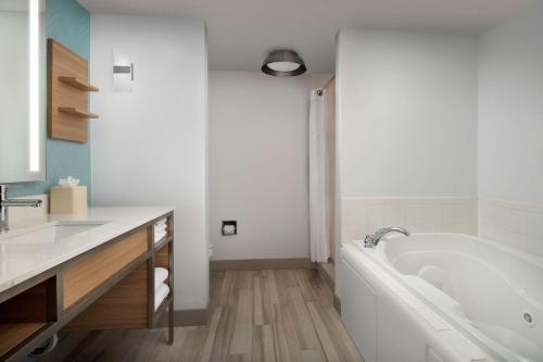 邓肯维尔达拉斯/邓肯维尔希尔顿花园酒店的白色的浴室设有浴缸和水槽。