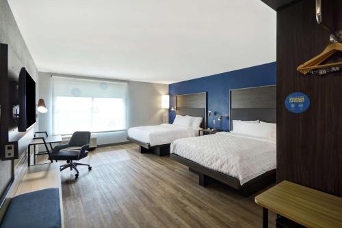 费尔伯恩Tru By Hilton Beavercreek Dayton的酒店客房 - 带两张床、一张桌子和一把椅子