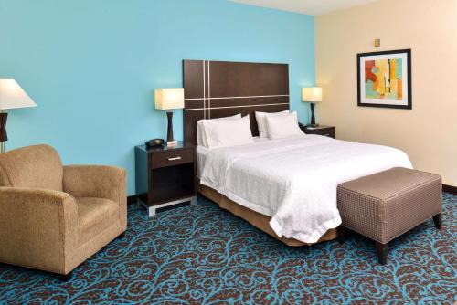 迈阿密斯堡Hampton Inn by Hilton Dayton South的配有一张床和一把椅子的酒店客房