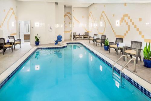 华盛顿华盛顿特区市中心希尔顿花园旅馆的游泳池位于酒店客房内,配有桌椅
