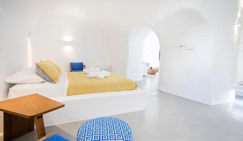 菲罗斯特法尼Rafael' s Mediteranian Cave Suites的白色卧室配有床和桌子