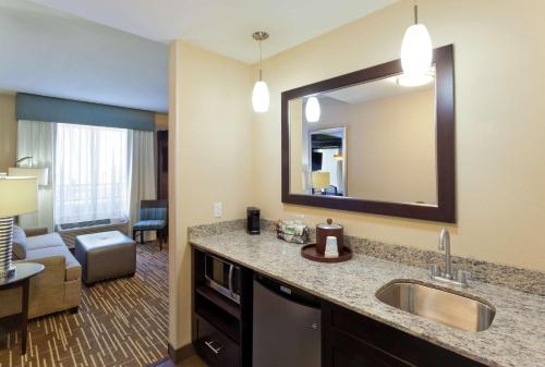 奥罗拉丹佛机场汉普顿套房酒店/盖特韦帕克的酒店客房设有水槽和客厅。