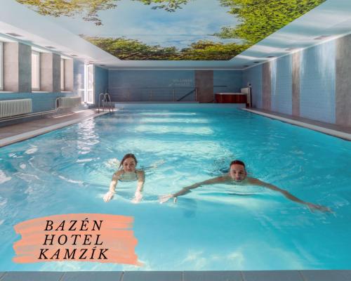 小莫拉夫卡Depandance hotelu Kamzík的两人在大型游泳池游泳
