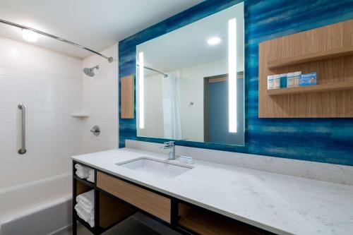 朗蒙特Hilton Garden Inn Longmont的一间带水槽和镜子的浴室