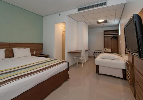 马瑙斯维尔弗斯机场快线酒店的配有一张床和一台平面电视的酒店客房