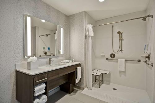 FairviewHome 2 Suites By Hilton Fairview Allen的浴室配有水槽、淋浴和浴缸。