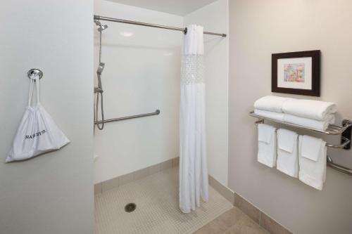 多森多森希尔顿恒庭旅馆&套房酒店的带淋浴和白色毛巾的浴室
