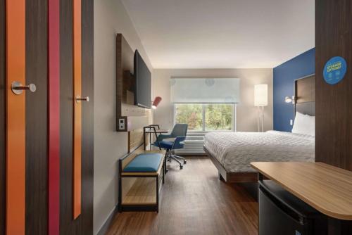 德卢斯Tru By Hilton Duluth Mall Area的酒店客房配有一张床、一张桌子和一把椅子。