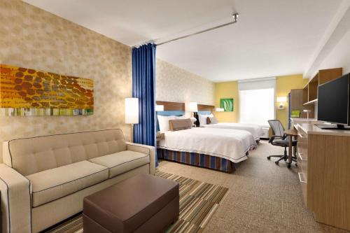 德斯坦德斯坦希尔顿欣庭套房酒店 的酒店客房,配有床和沙发