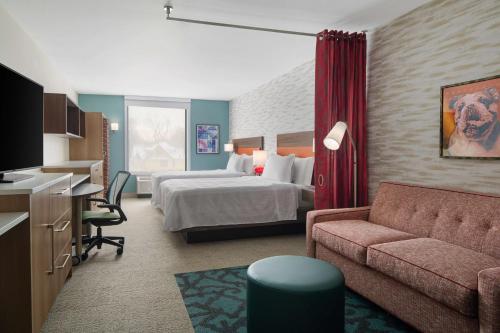 德梅因Home2 Suites by Hilton Des Moines at Drake University的酒店客房,配有床和沙发