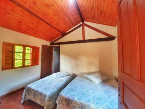圣托梅-达斯莱特拉斯Chalé e Camping Elementais的一间卧室设有一张床和木制天花板