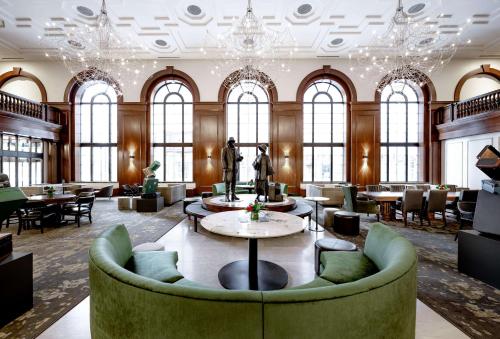 德梅因Hotel Fort Des Moines, Curio Collection By Hilton的大堂设有带桌椅的大房间