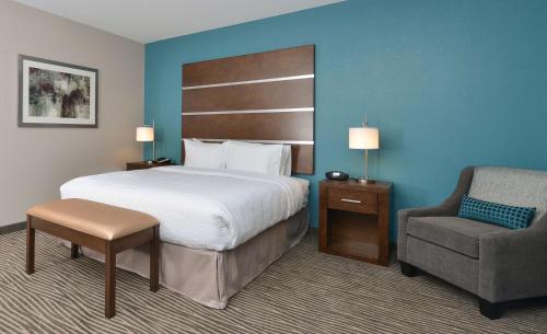 德梅因得梅因市中心汉普顿套房酒店的配有一张床和一把椅子的酒店客房