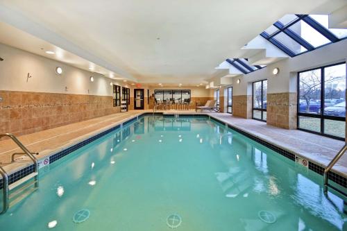 坎顿底特律坎顿希尔顿恒庭旅馆&套房酒店的大楼内的一个蓝色海水游泳池