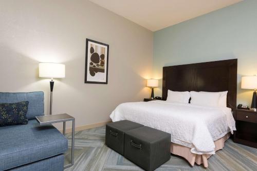 克林顿底特律罗斯维尔汉普顿旅馆的酒店客房,配有床和沙发