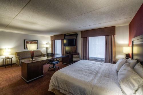 罗缪勒斯底特律/罗穆卢斯机场汉普顿酒店的配有一张床和一张书桌的酒店客房