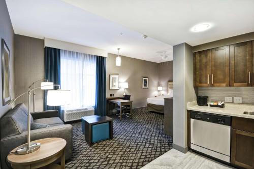 沃伦Homewood Suites By Hilton Warren Detroit的酒店客房设有床和客厅。