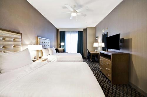 沃伦Homewood Suites By Hilton Warren Detroit的酒店客房设有两张床和一台平面电视。