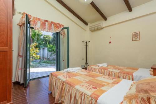 维勒克哈德哈Villa Dimitrios的一间卧室设有两张床,一扇门通往庭院