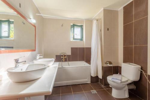 维勒克哈德哈Villa Dimitrios的一间带水槽、浴缸和卫生间的浴室