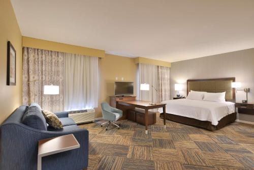 奇珀瓦福尔斯奇普瓦瀑布汉普顿套房酒店 的配有一张床和一张书桌的酒店客房