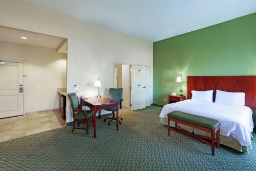 埃尔帕索埃尔帕索西汉普顿酒店的酒店客房带一张床、一张桌子和椅子