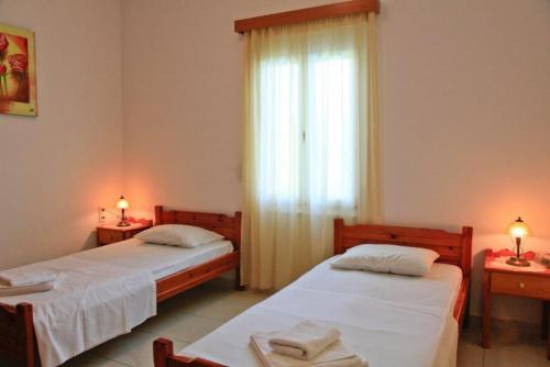 维勒克哈德哈Villa Dimitris的配有两盏灯和一扇窗户的客房内的两张床
