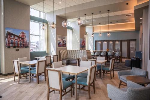 伊利Hampton Inn & Suites Erie Bayfront的一间带桌椅的餐厅和一间酒吧