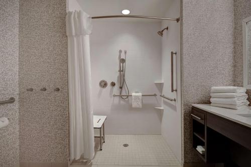 东汉诺威Home2 Suites East Hanover, NJ的带淋浴和盥洗盆的白色浴室