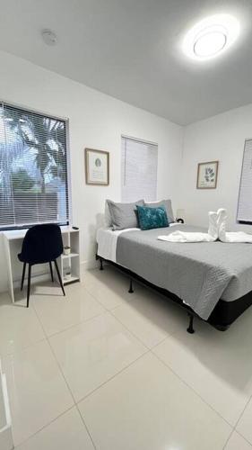 迈阿密Stanza Hearth of Miami Design District and Wynwood, Parking, Laundry, Workstation, Fully equipped Apts, 24/7 Guest support #2的卧室配有床、椅子和窗户。