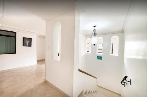 麦德林Hotel Lukas的房屋内带白色墙壁和楼梯的走廊