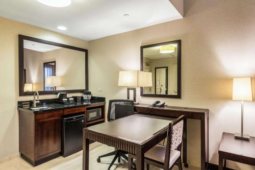 伊丽莎白Embassy Suites by Hilton Newark Airport的配有书桌和桌子的酒店客房
