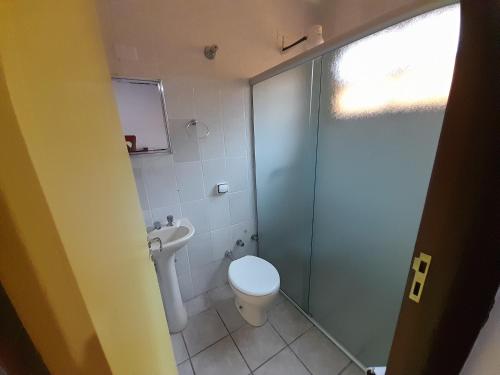博西坎加Mandala casa 3 dorms cond fech piscina churrasqueira的一间带卫生间和玻璃淋浴间的浴室