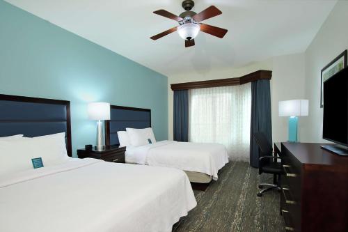 达尼亚滩劳德代尔堡机场邮轮码头希尔顿惠庭套房酒店的酒店客房配有两张床和吊扇。