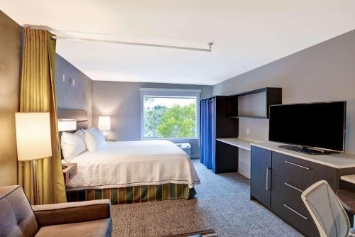 米拉玛米拉玛劳德代尔堡希尔顿欣庭套房酒店的配有一张床和一台平面电视的酒店客房