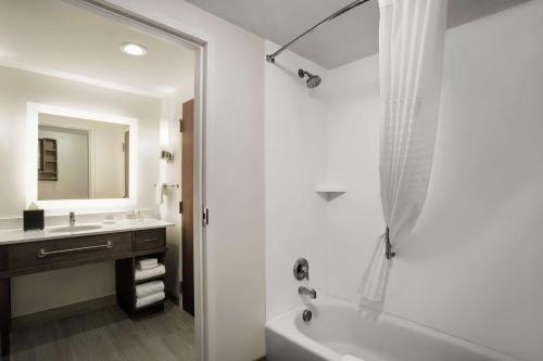 佛罗伦萨Homewood Suites By Hilton Florence的白色的浴室设有浴缸和水槽。