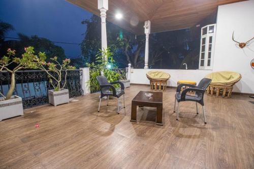 RatmalanaSpacious 4BR 4BA Family Villa wt Balcony & Lavish Garden的铺有木地板的客房,配有桌椅