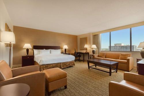 韦恩堡韦恩堡大韦恩希尔顿会议中心酒店的酒店客房配有一张床、一张沙发和椅子。