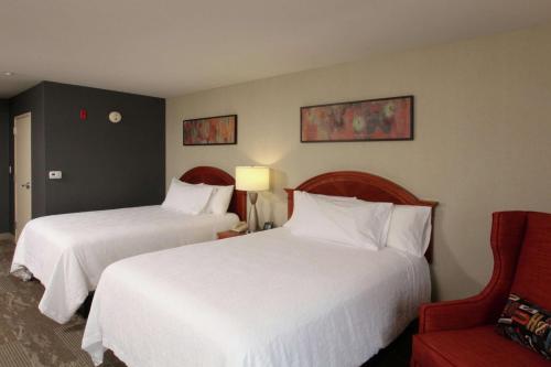 艾尔韦高地希尔顿花园酒店斯波坎机场店的酒店客房,设有两张床和一张红色椅子