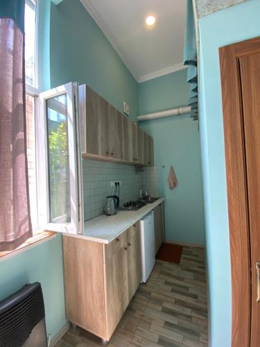 博尔若米Eli’s home的厨房配有木制橱柜和窗户。