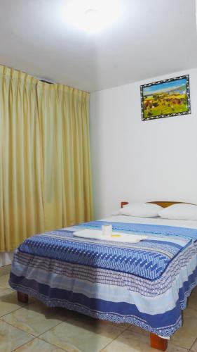 拉梅尔塞Hospedaje chanari的一间卧室配有一张带蓝色毯子的床