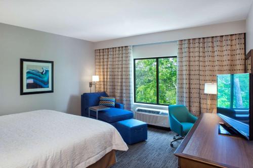 格尔夫海岸湾岸汉普顿酒店的酒店客房配有一张床、一张桌子和一把椅子。