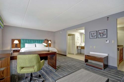 圭尔夫圭尔夫敦汉普顿套房酒店的配有一张床和一张书桌的酒店客房