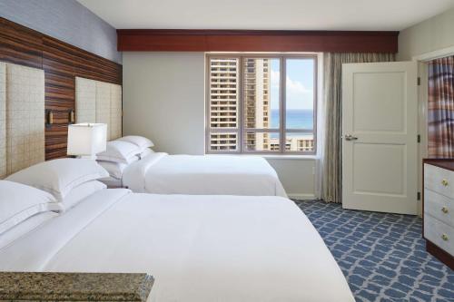 檀香山Hilton Grand Vacations Club Grand Waikikian Honolulu的酒店客房设有三张床和窗户。