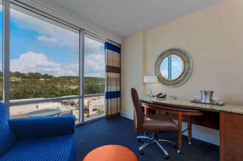 布兰森Hilton Branson Convention Center的客房设有桌椅和大窗户。