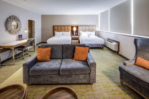 亨廷顿DoubleTree by Hilton Huntington, WV的酒店客房,配有沙发和两张床