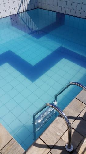瓜鲁雅Dom Pedro 54的大型蓝色游泳池,面朝水面